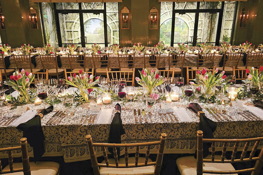 Two long tables, elegantly decorated, for a large group wine tasting.